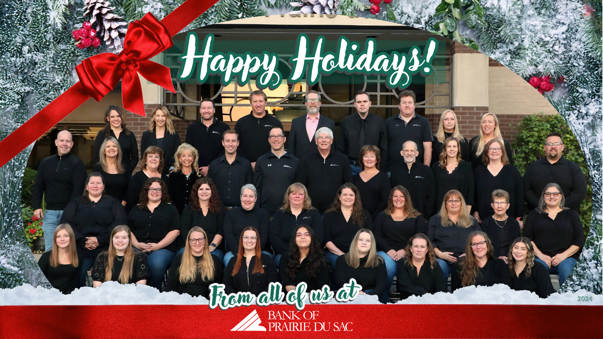 Bank staff pose for a photo in front of the bank's main building in Prairie du Sac.